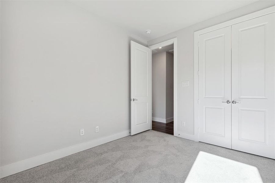 Unfurnished bedroom with a closet and light colored carpet