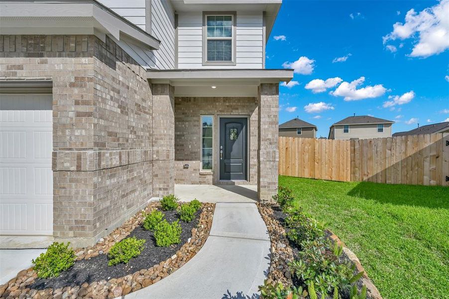 Beautifully landscaped walkway leading to the front door with fixed speakeasy window