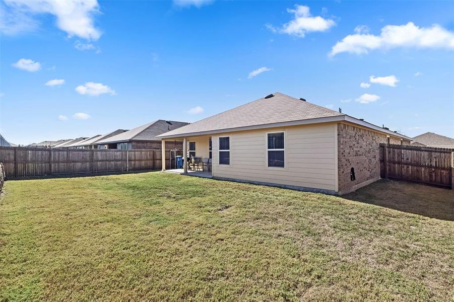 Back of property featuring a yard and a patio area