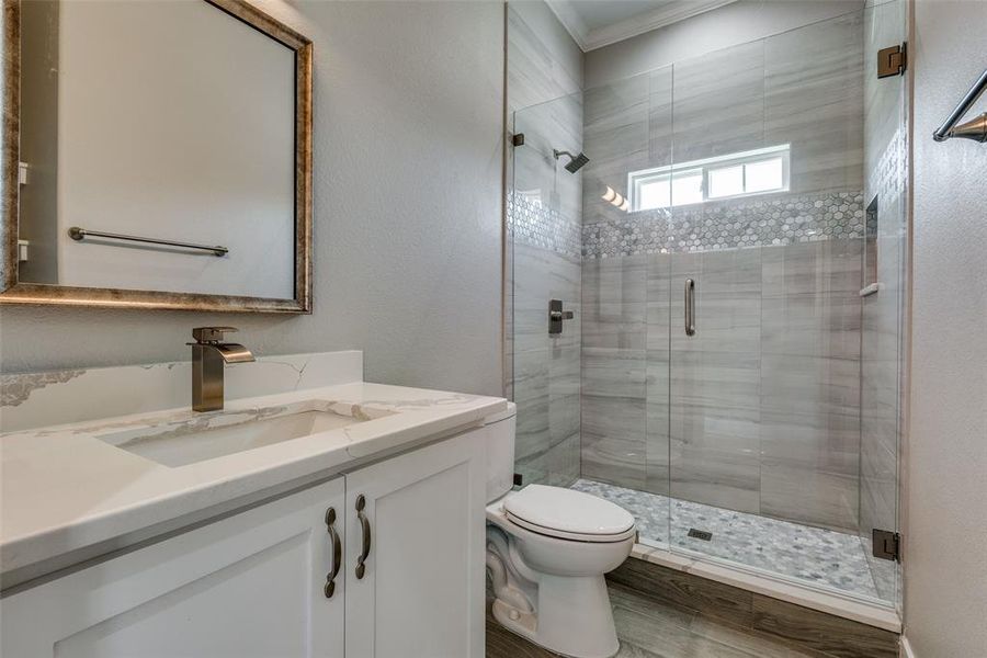 Bathroom with vanity, crown molding, an enclosed shower, and hardwood / wood-style floors