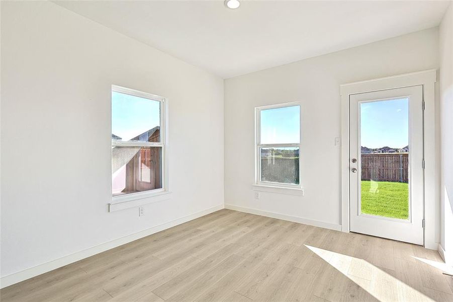 Unfurnished room featuring light hardwood / wood-style floors and a wealth of natural light