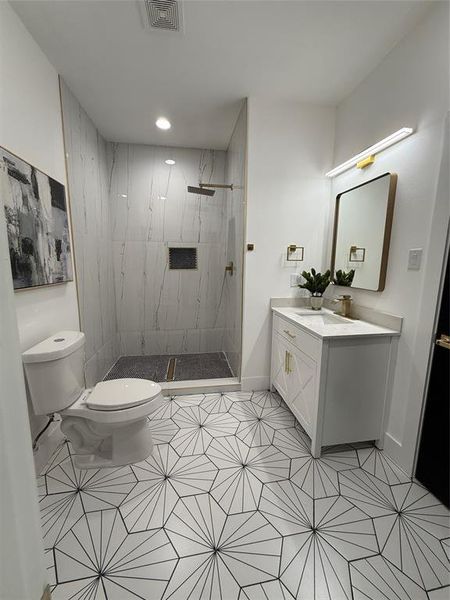 Secondary Bathroom with vanity, tiled shower and tile patterned flooring