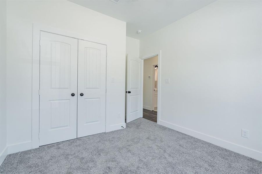 Unfurnished bedroom with carpet and a closet