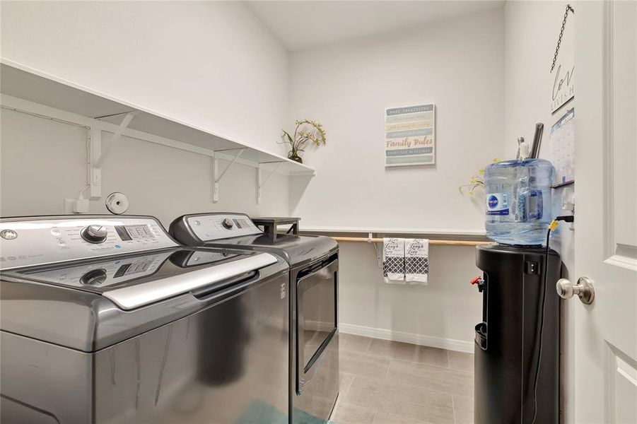 Practical Laundry Room - Space for a full washer and dryer, long shelf, custom folding and hanging shelf, providing practicality and organization.