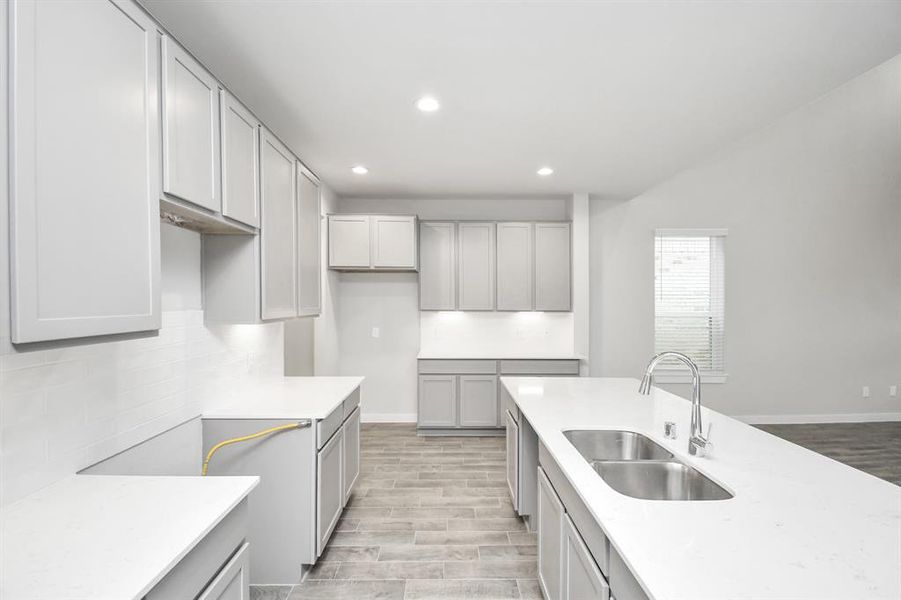 This generously spacious layout boasts a massive granite island, high ceilings, soft-close cabinets, granite countertops, stainless steel appliances, a sleek tile backsplash, and recessed lighting.