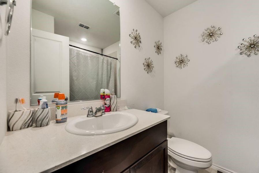 Bathroom featuring vanity, toilet, and walk in shower