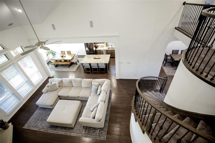 Living room featuring dark hardwood / wood-style floors, high vaulted ceiling, and ceiling fan