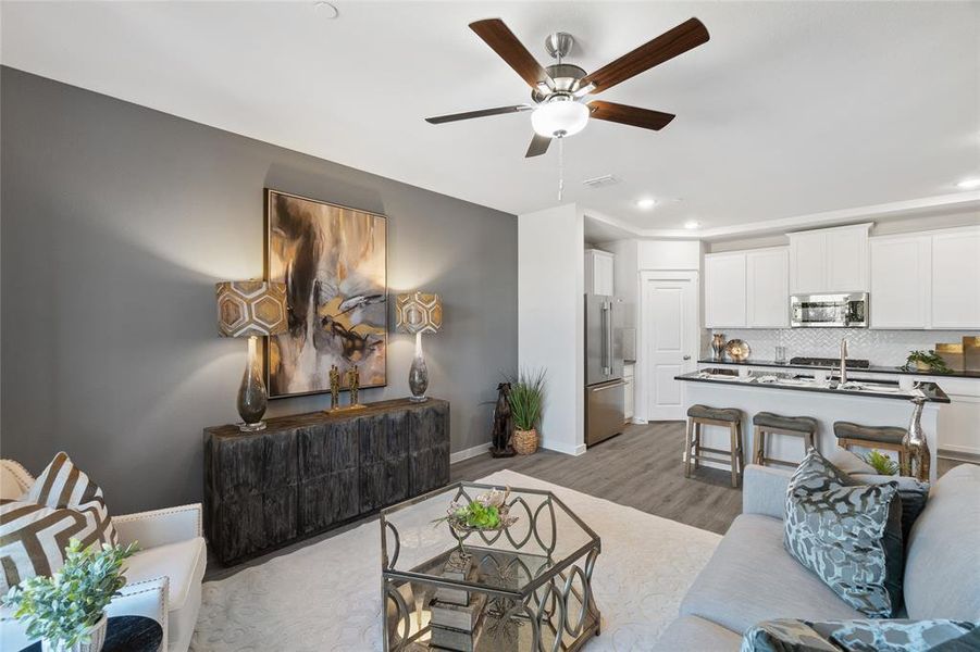 Living room with light hardwood / wood-style flooring and ceiling fan