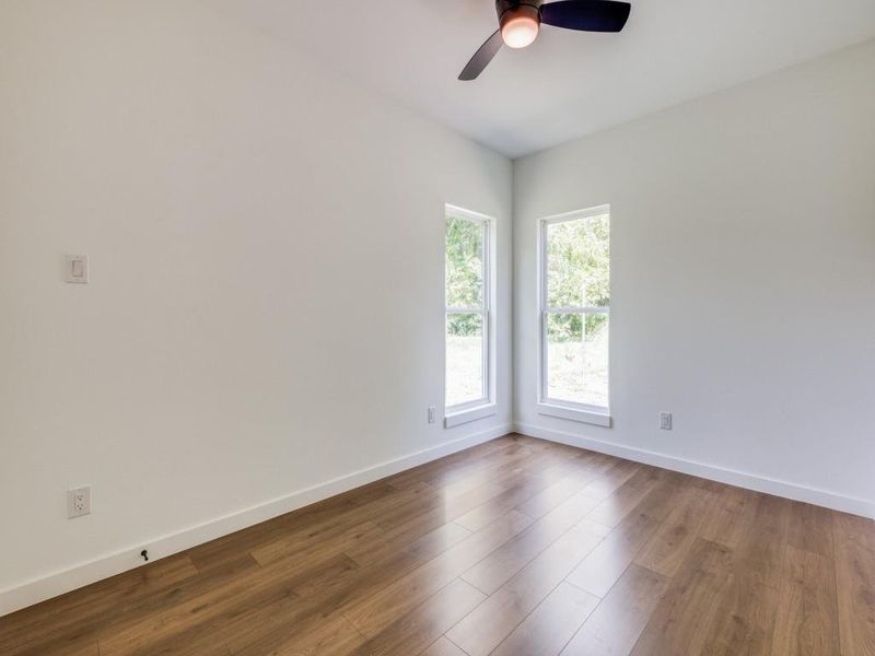 Spare room with wood-type flooring and ceiling fan