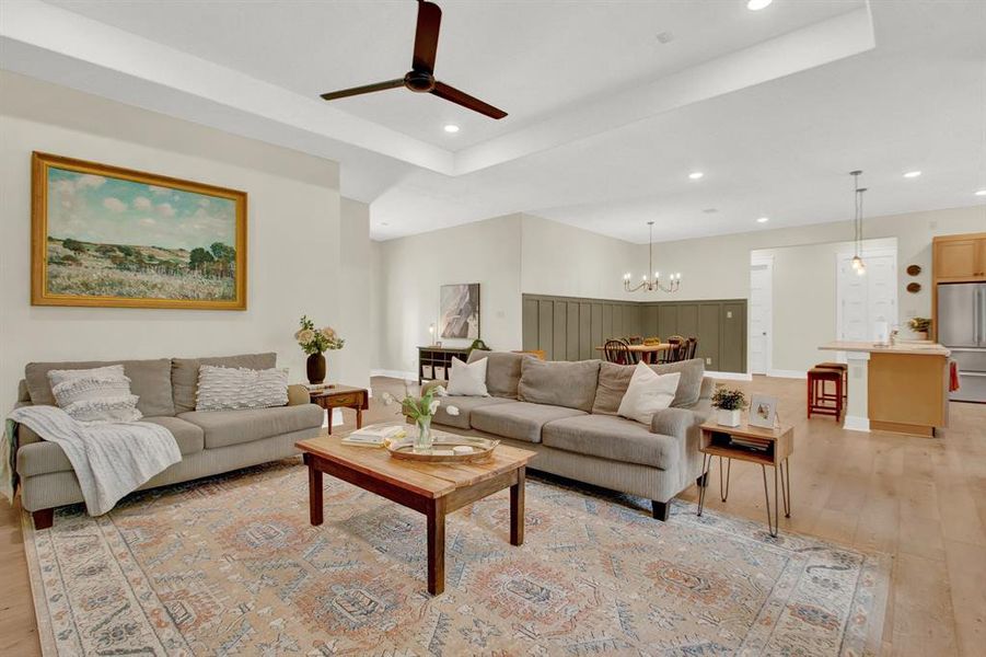 An open-plan living area featuring plenty of space for seating a large number of guests. It's place in the home offers a seamless transition to the dining space and kitchen. The room is well-lit, with a warm and welcoming ambiance.