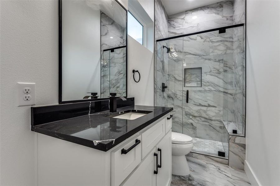 Spacious bathroom with natural stone and lots of natural light.