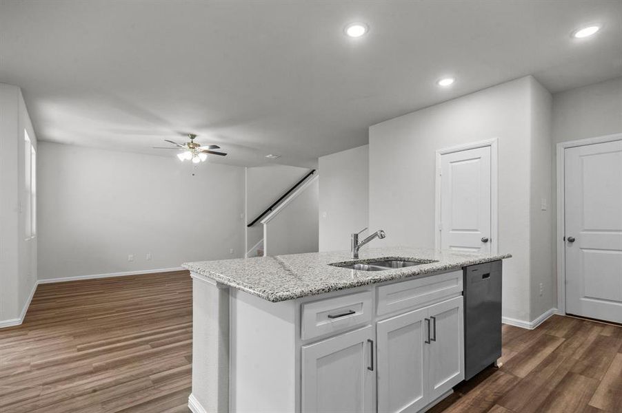 Kitchen featuring sink, an island with sink, white cabinets, dishwasher, and dark hardwood / wood-style flooring