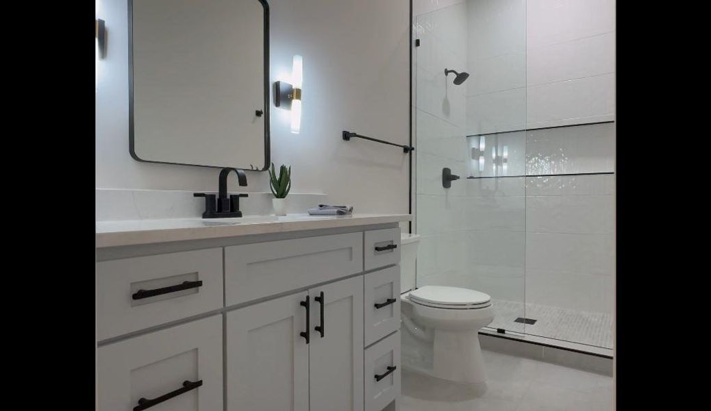 Bathroom with vanity, an enclosed shower, tile patterned flooring, and toilet