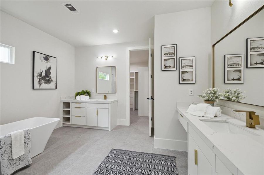 Luxurious primary bathroom boasts spa-like amenities, including a soaking tub, walk-in shower, and dual vanities.