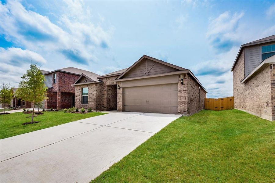 View of front of property featuring a garage and a front lawn