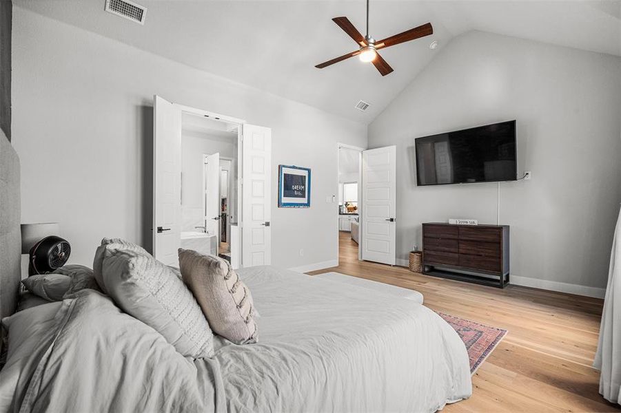 Bedroom featuring high vaulted ceiling, connected bathroom, light wood-type flooring, and ceiling fan