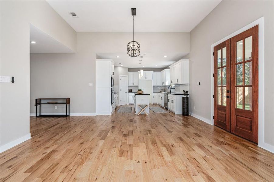 Foyer featuring an inviting chandelier, light wood-type flooring, french doors, and sink