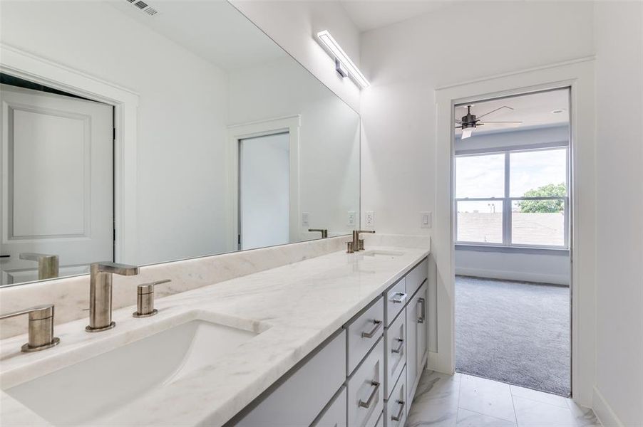 Bathroom with tile floors, dual vanity, and ceiling fan