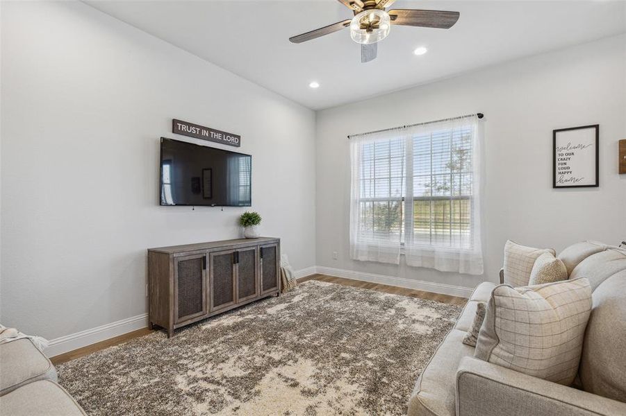 Living room with dark hardwood / wood-style flooring and ceiling fan