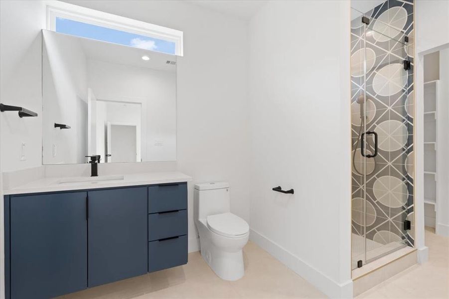 Bathroom with vanity, toilet, a shower with door, and tile patterned floors