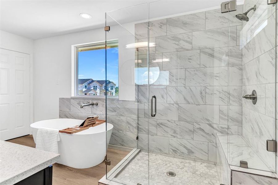 Bathroom with tile walls, a shower with shower door, and hardwood / wood-style floors