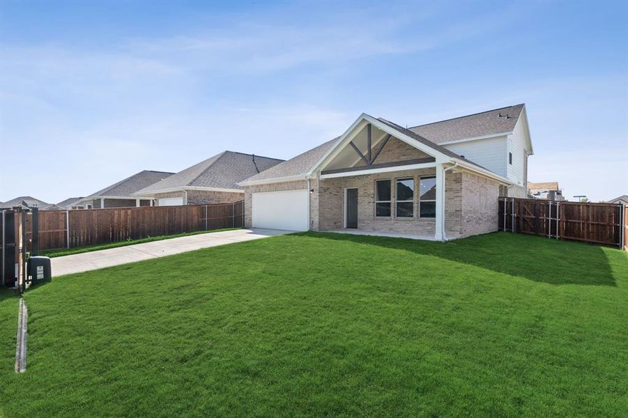 Back of property featuring a lawn and a garage