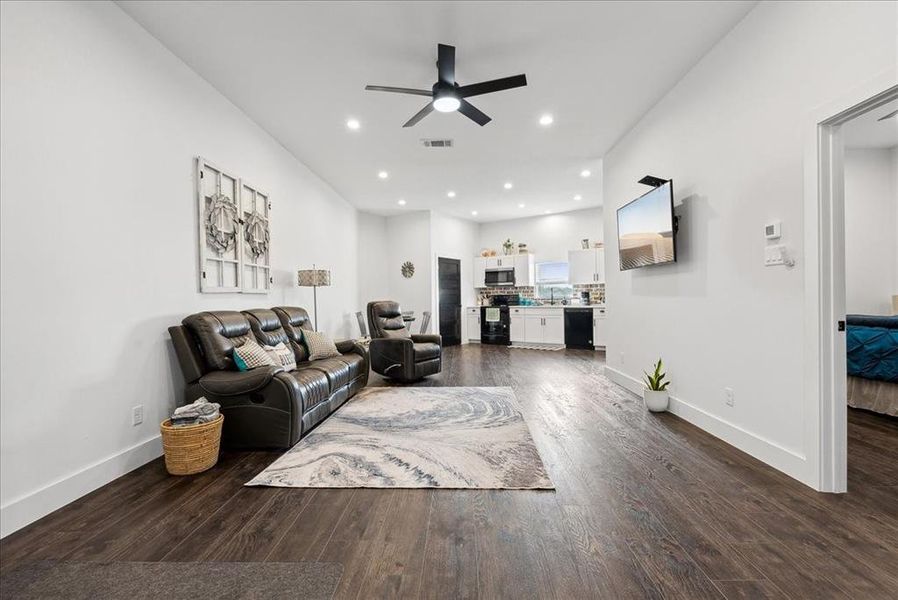 Living room featuring ceiling fan and dark hardwood / wood-style floors