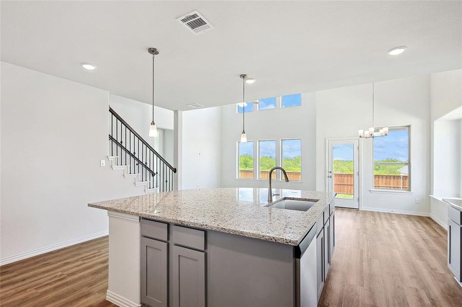 Kitchen with a center island with sink, sink, light hardwood / wood-style floors, and gray cabinets