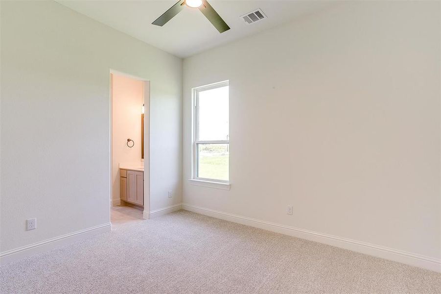 Carpeted spare room featuring ceiling fan