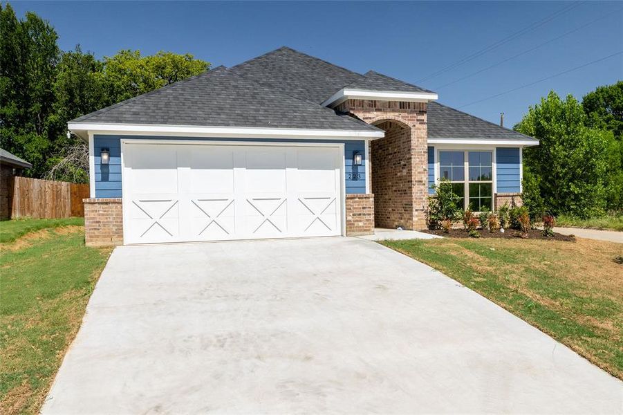 View of front of property with a garage and a front lawn