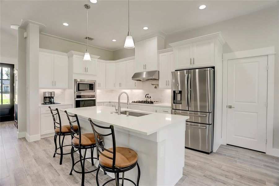 CRAFT CULINARY MASTERPIECES IN THIS STATE-OF-THE-ART KITCHEN, EQUIPPED WITH STAINLESS STEEL APPLIANCES, SLEEK WHITE CABINETRY, AND A SPACIOUS GRANITE COUNTERTOP, ALL DESIGNED TO OFFER THE PERFECT BLEND OF STYLE AND PRACTICALITY.