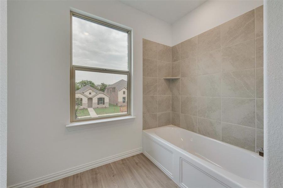 Bathroom featuring hardwood / wood-style flooring and tiled shower / bath combo