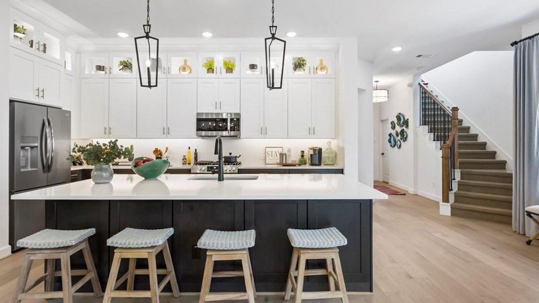 The kitchen boasts a stunning 9-foot island with a luxurious quartz countertop. This expansive surface provides ample space for meal preparation, dining, and entertaining.