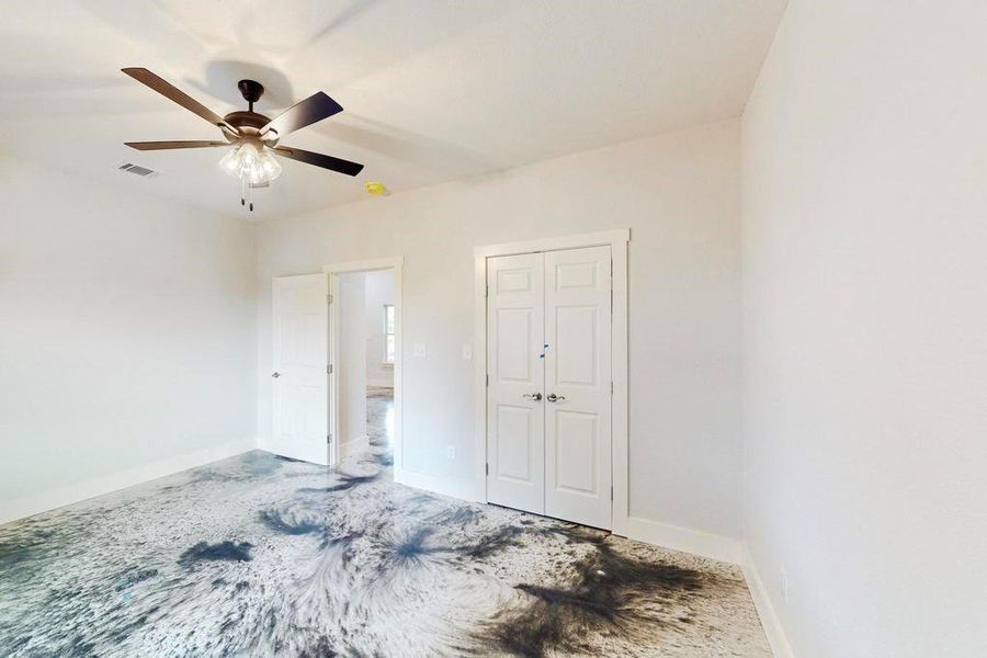 Unfurnished bedroom featuring ceiling fan and a closet