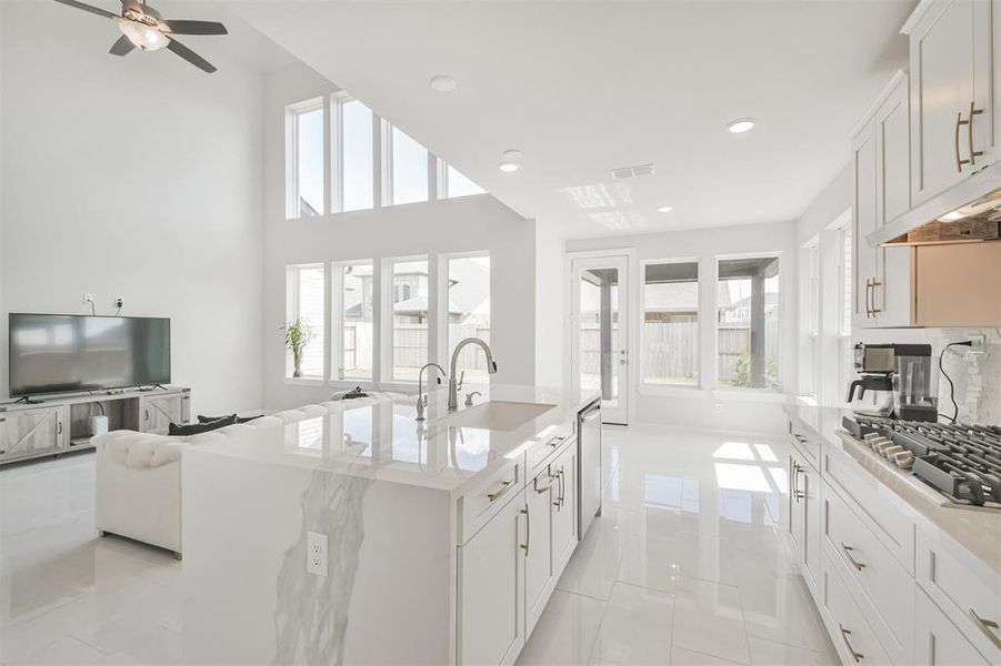 This is a modern, open-concept kitchen with white high-gloss cabinetry.