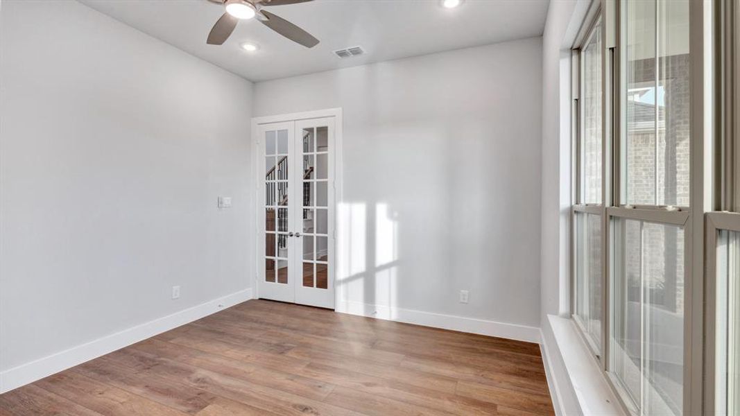 Unfurnished room featuring ceiling fan, french doors, and hardwood / wood-style flooring