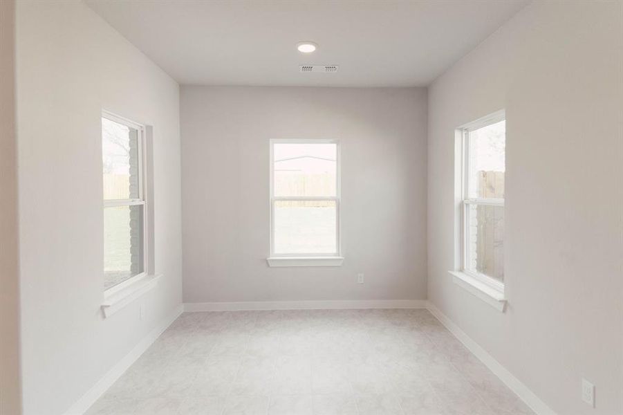 Spare room featuring light tile patterned flooring and plenty of natural light