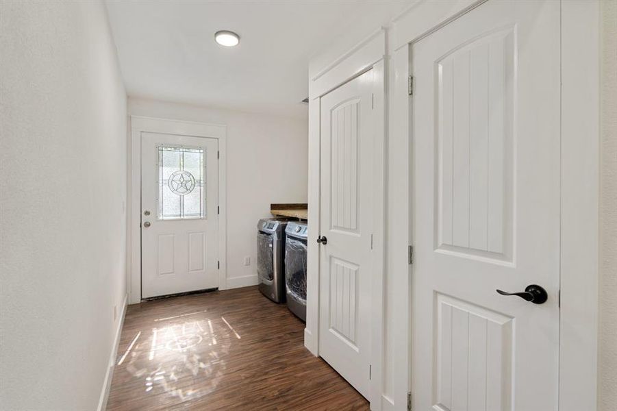 Doorway featuring washer and clothes dryer and dark wood-type flooring