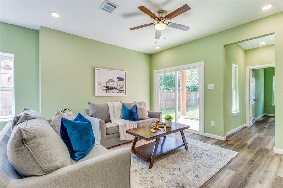 Living room with ceiling fan and hardwood / wood-style floors