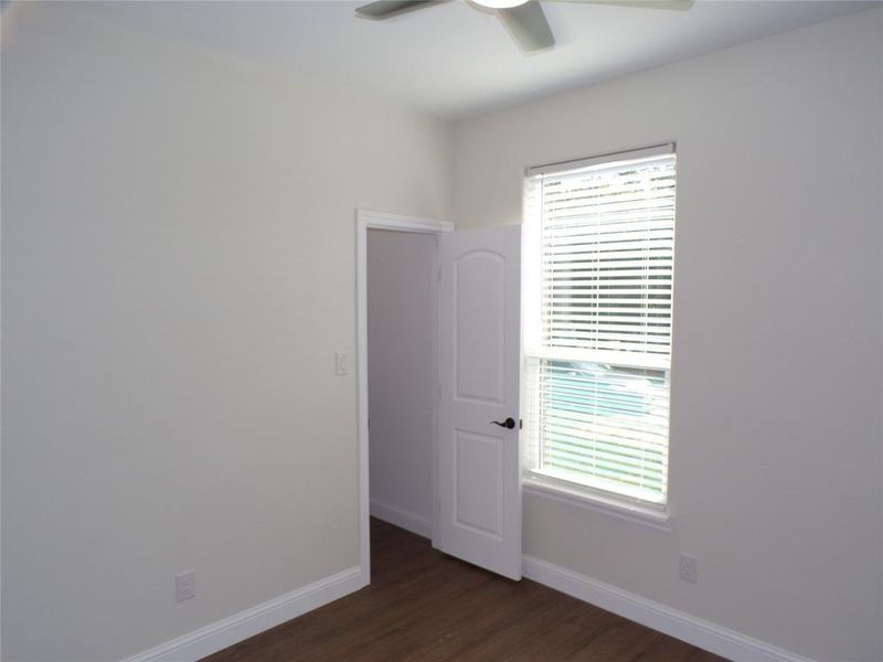 2nd bedroom featuring plenty of natural light, dark hardwood / wood-style floors, and ceiling fan