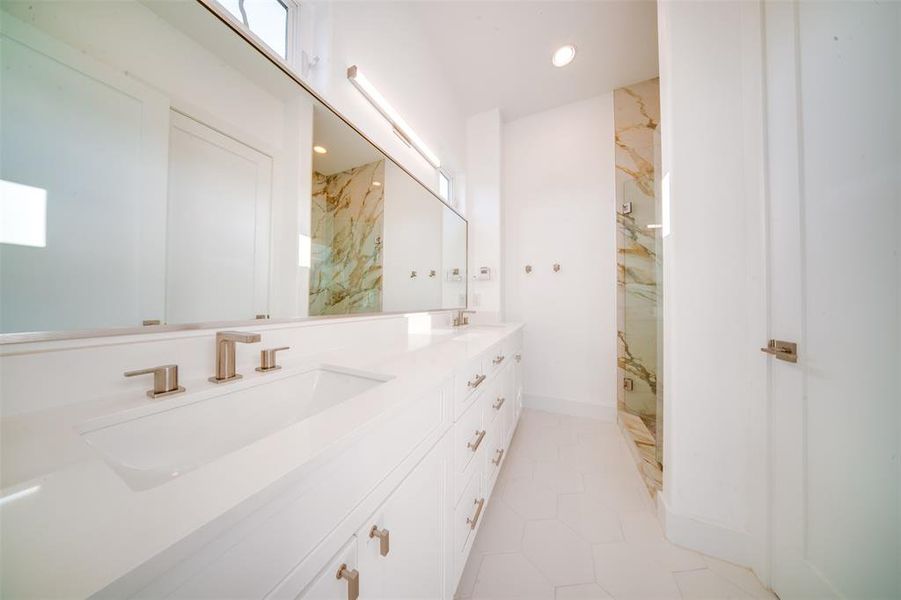 Bathroom featuring vanity, tiled shower, and tile patterned floors