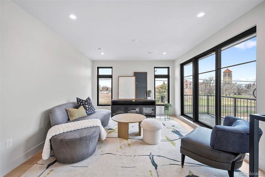 At the top of the stairs, the second level features a flex space with a balcony toward the Rocky Mountains.