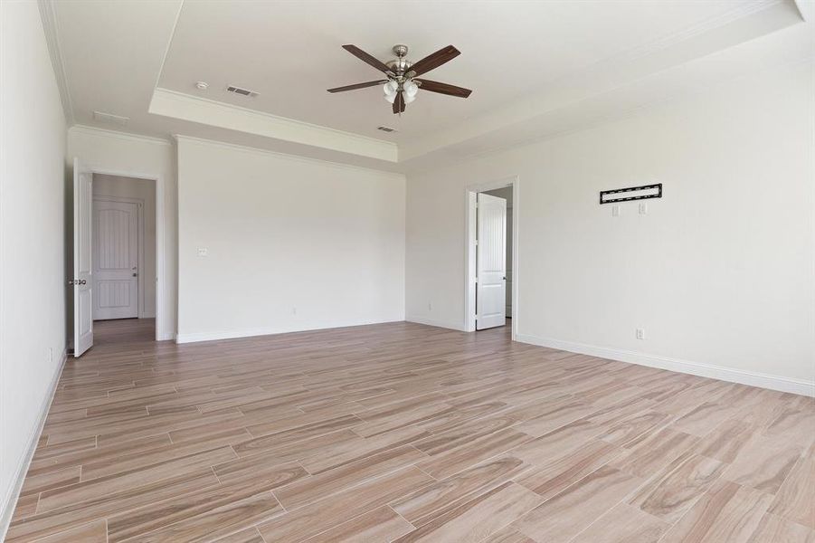 Unfurnished room with ceiling fan and a raised ceiling