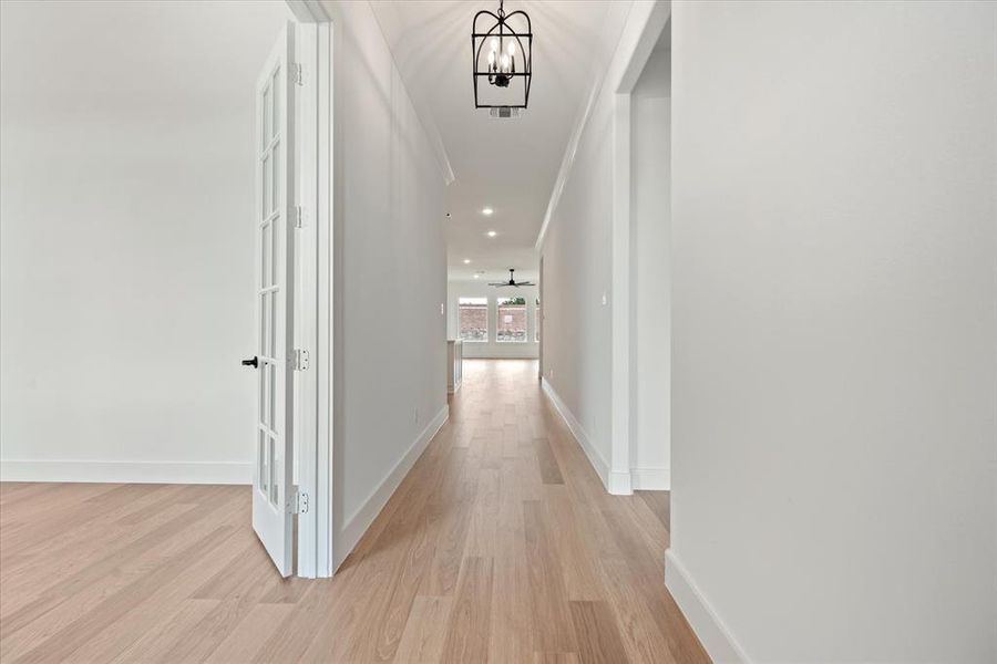 Hall featuring a notable chandelier and light wood-type flooring