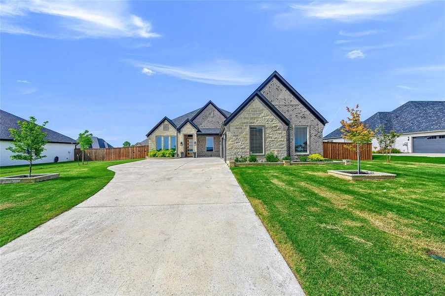 View of front of house featuring an oversized 3 car garage and a front lawn