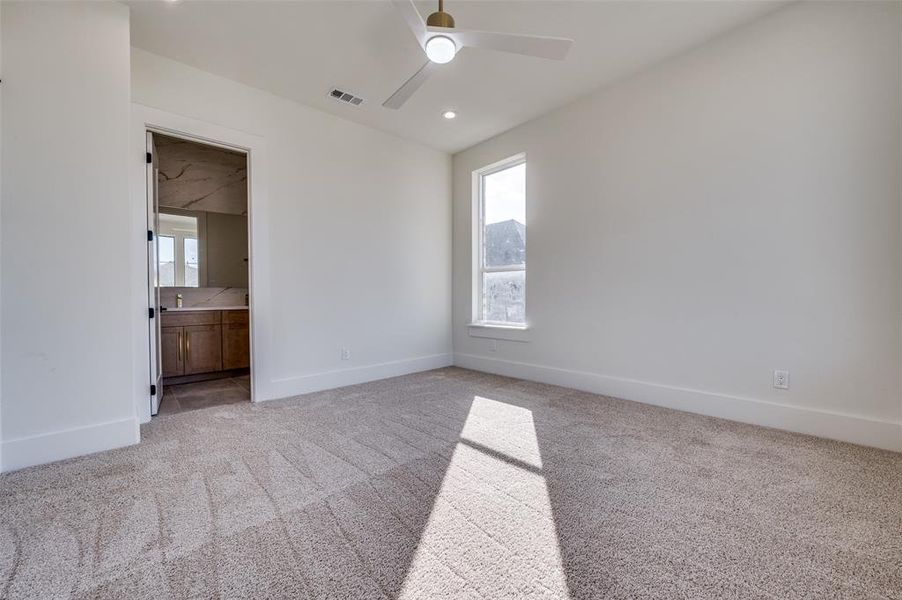 Carpeted spare room with ceiling fan