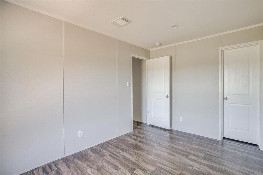 Unfurnished room featuring crown molding and dark hardwood / wood-style flooring