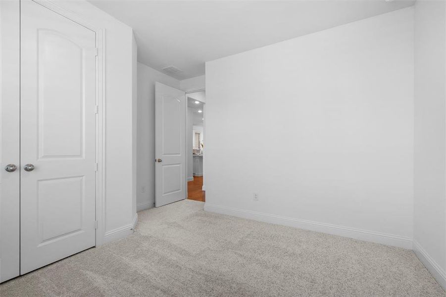 Unfurnished bedroom with light carpet