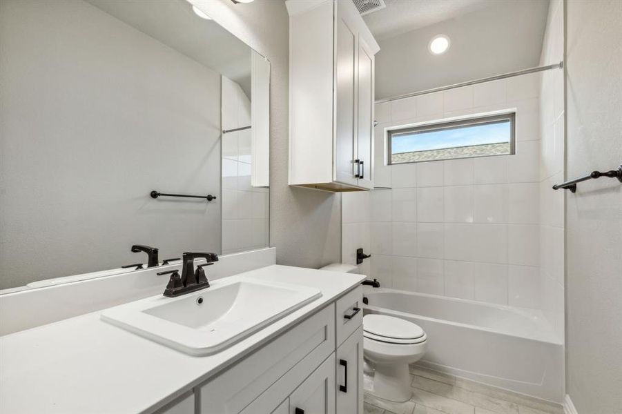 Full bathroom with vanity, toilet, and tiled shower / bath