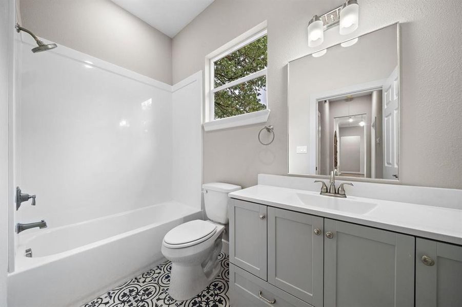 Baths 2 and 3 both contain the same gorgeous blue and gray patterned tile, 48 in vanities with loads of storage, Moen fixtures, comfort height commodes, and white cultured marble tub surround. No grout lines to clean!